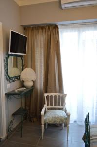 Una sala de estar con una silla y un televisor. en B&B Al Golfo, en Salerno
