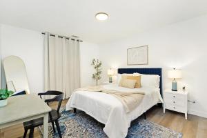 a white bedroom with a bed and a desk at Chic & Cozy Condo in Manhattan with Free Parking & WiFi in Manhattan