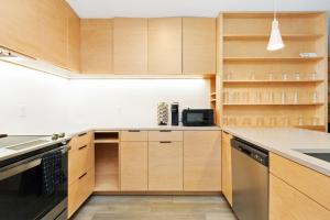 a kitchen with wooden cabinets and a counter top at Chic & Cozy Condo in Manhattan with Free Parking & WiFi in Manhattan
