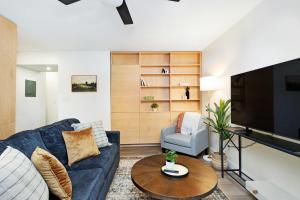 a living room with a blue couch and a tv at Chic & Cozy Condo in Manhattan with Free Parking & WiFi in Manhattan