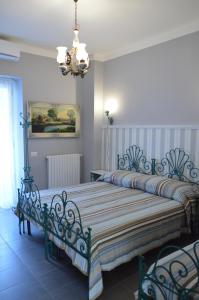 Un dormitorio con dos camas y una lámpara de araña. en B&B Al Golfo, en Salerno