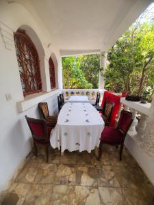 a dining room with a white table and chairs at Louisiana Guest House in Ambohibao