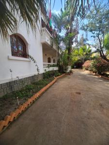 an empty road in front of a white building at Louisiana Guest House in Ambohibao +12 photos