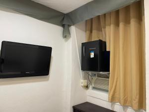 a flat screen tv hanging on a wall at Hospedagem Ledo in Rio de Janeiro