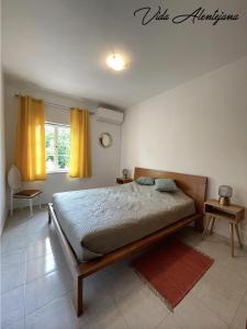 a bedroom with a bed and a window with yellow curtains at Vida Alentejana in Reguengos de Monsaraz