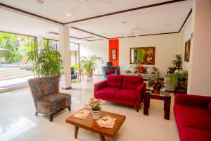 a living room with a red couch and chairs at Best Western Hotel & Casino Kamuk in Manuel Antonio