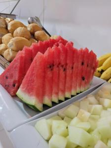 a tray of watermelon and other fruits on a table at Pousada Luar in Santa Cruz Cabrália