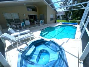 a large swimming pool with chairs and a swimming pool at Upgraded Pool Villa Spa Southern Dunes in Haines City