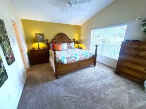 a bedroom with a bed and a dresser and a window at Upgraded Pool Villa Spa Southern Dunes in Haines City +16 photos