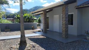 a house with two palm trees in front of it at Suítes Garden in Pomerode