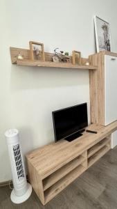 a television on a wooden entertainment center in a living room at Comfort Place Brno Apartments in Brno