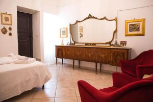 a bedroom with a dresser with a mirror and red chairs at L'ulivo - A due passi dal Mare in Mola di Bari