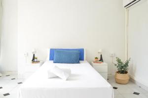 een slaapkamer met een wit bed en een blauw kussen bij VM Sun & Beach in Almería