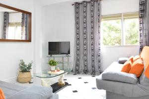 een woonkamer met een bank en een tv bij VM Sun & Beach in Almería