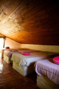 fila de camas en una habitación con techos de madera en La Carmencita casa de campo, Manzanares, Pilar, en Pilar 165 fotos más