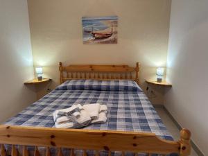 a bedroom with a bed with a blue and white checkered bedspread at Villaggio Malfidano in Buggerru