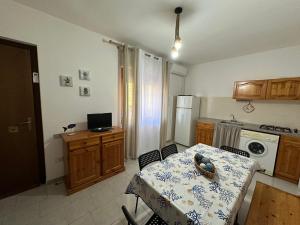 a kitchen with a table and a kitchen with a table and chairs at Villaggio Malfidano in Buggerru