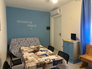 a room with a table with chairs and a blue wall at Villaggio Malfidano in Buggerru