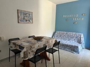 a dining room with a table and chairs and a couch at Villaggio Malfidano in Buggerru