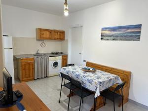 a kitchen with a table with chairs and a microwave at Villaggio Malfidano in Buggerru