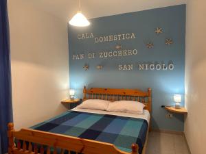 a bedroom with a bed with a blue wall at Villaggio Malfidano in Buggerru