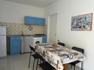a kitchen with a table and chairs and a kitchen with blue cabinets at Villaggio Malfidano in Buggerru