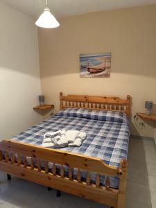 a bedroom with a wooden bed with a blue and white checkered bedspread at Villaggio Malfidano in Buggerru