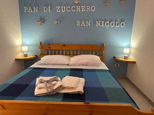 a bedroom with a bed with towels on it at Villaggio Malfidano in Buggerru