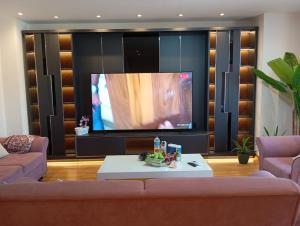 a living room with a couch and a large tv at Taksim Perfect Residence, 3 bedrooms, pool, sauna, gym in Istanbul +172 photos