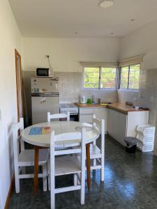 a kitchen with a table and chairs in a kitchen at Monoambiente Acantilados Single fin a 5 cuadras de la playa in Mar del Plata