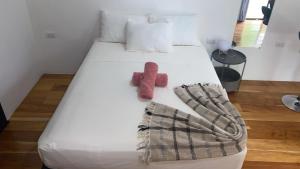 a bed with red socks and a blanket on it at Cahuita Nest Containers studio homes in Cahuita