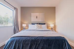 a bedroom with a large bed and a window at Galaxy 3BR Modern Home with Fireplace Outdoor Spa in Lake Tekapo