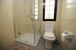 a bathroom with a toilet and a glass shower at BHF Residences Bordadeira in Arco da Calheta +14 photos