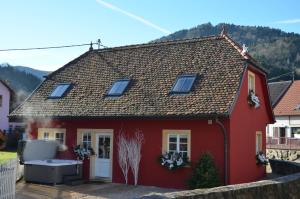 une maison rouge avec un bain à remous en face de celle-ci dans l'établissement Doller Villa 4 stars Hot Tub Mountain Ski Ballon d'Alsace, à Sewen