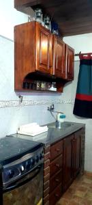a kitchen with a sink and wooden cabinets at Mar del Plata in Mar del Plata