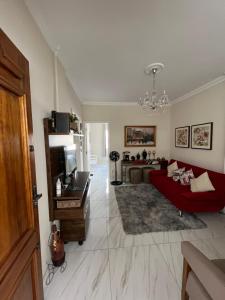a living room with a red couch and a television at Apartamento Fontana di Trevi Centro Serra Negra in Serra Negra