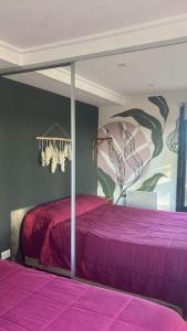 a bedroom with a purple bed with a painting on the wall at Casita Petra in Tandil