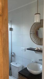 a bathroom with a toilet and a sink and a mirror at Casita Petra in Tandil