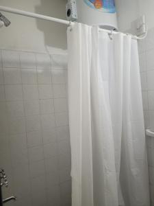 a white shower curtain in a bathroom with at Depto Céntrico II in Corrientes