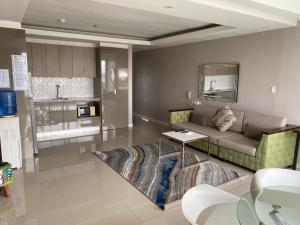 a living room with a couch and a kitchen at Chequers Suites Subic Bay in Olongapo