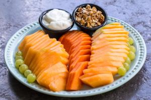 a plate of fruit and vegetables on a table at LOL-HA Hotel Boutique in Cancún