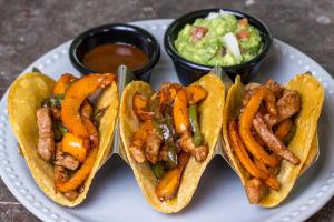 three hot dogs on a plate with sauce and dip at LOL-HA Hotel Boutique in Cancún