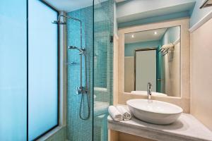 un bagno con lavandino e doccia in vetro di Makarios Hotel a Kamari