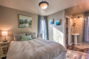 a bedroom with a large bed and a bathroom at Modern Mountain Retreat with Views Ski, Golf and Hike in Angel Fire