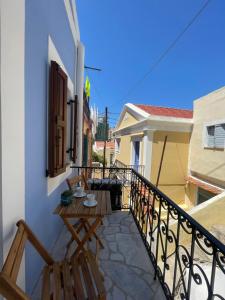 a balcony with a table and chairs on a building at Serenity Luxury Apartment in Symi