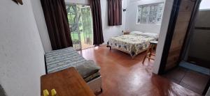 een kamer met een bed, een tafel en een raam bij Posada Meztitla in Tepoztlán