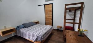een slaapkamer met een bed en een houten ladder bij Posada Meztitla in Tepoztlán +12 foto's