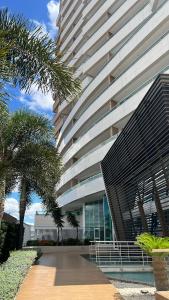Un gran edificio con una palmera delante. en Apartamento confortável, localização extra -recepção 24h- Varanda com vista panorâmica, en Juazeiro do Norte 11 fotos más