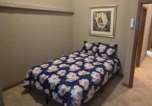 a bedroom with a bed with a blue and white comforter at Vibrant Living in Harmony, unit C in Seattle