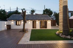 a house with a green yard with a palm tree at La Moderna Suites in Málaga